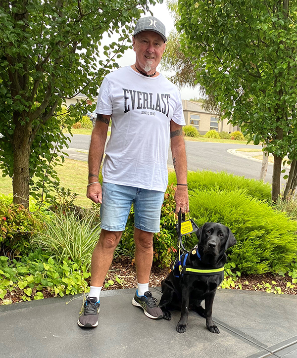 Dave standing next to Seeing Eye Dog Levi in harness