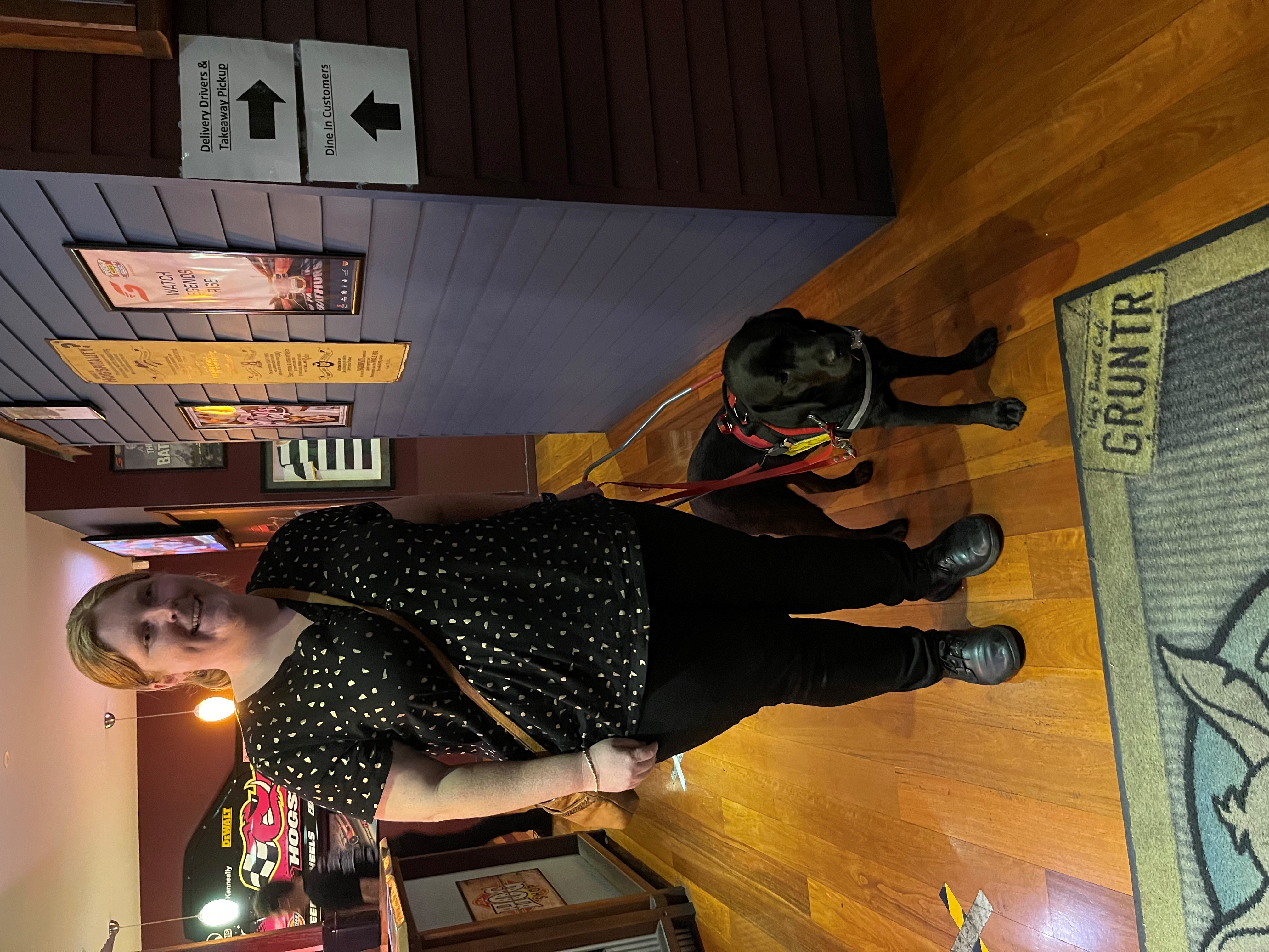 Isabella at a restaurant with Seeing Eye Dog Penny by her side.
